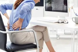 Bulk billing chiropractor Gold Coast: affordable care guide 1 Lady sitting in chair with back pain